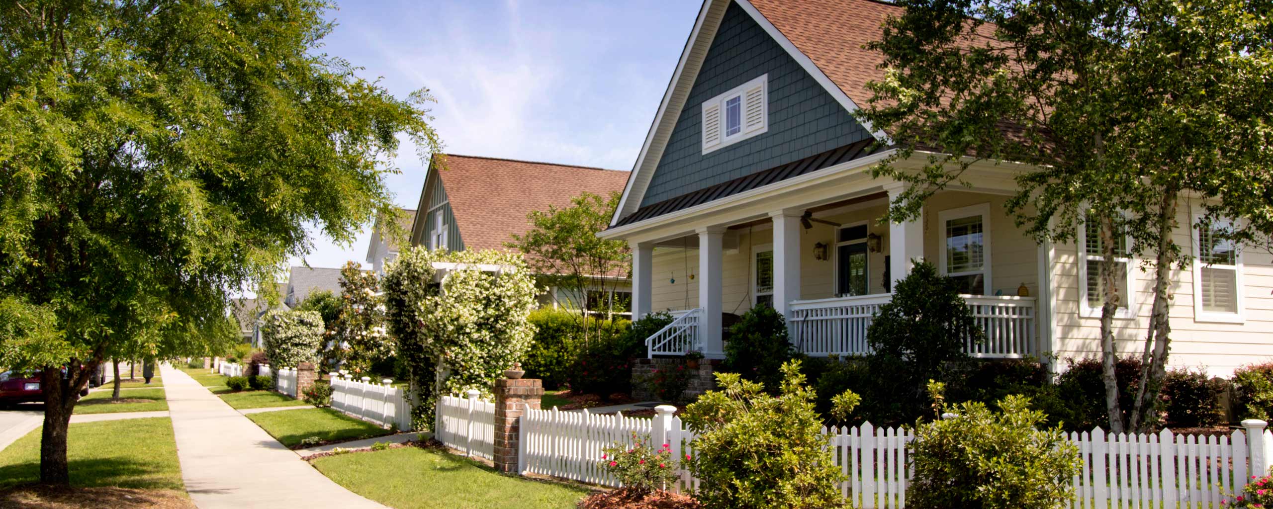 Front porches and picket fences on a tree-lined street